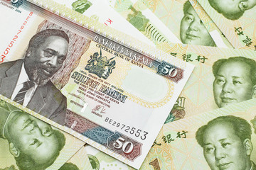 A close up image of a fifty Kenyan shilling bank note in macro with Chinese one yuan bills