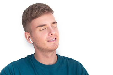 Obraz premium Szczęśliwy przystojny facet, młody wesoły piękny mężczyzna słuchający muzyki, ulubiona piosenka w słuchawkach bezprzewodowych, słuchawki z zamkniętymi oczami, marzy, ciesząc się, relaksując, na białym tle.