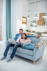 Fototapeta premium Daughter with father looking at laptop on sofa at home.