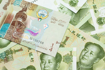 A colorful quarter dinar bank note from Kuwait close up in macro with Chinese one yuan bills