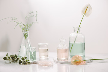 Perfume oils concept. Laboratory glassware with infused floral water on table