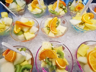 Fruit salad with strawberries, kiwi, orange, banana and pineapple in a plastic glass