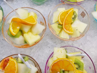 Fruit salad with strawberries, kiwi, orange, banana and pineapple in a plastic glass