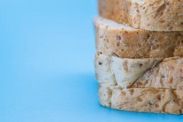 Close up of sliced whole wheat bread on blue background
