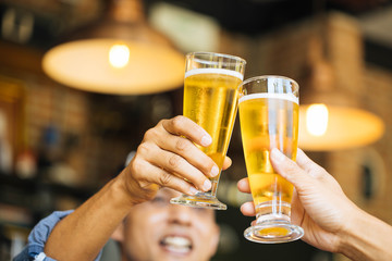 A man wearing a denim shirt and a glass of beer in the bar