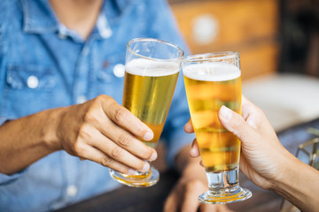 A man wearing a denim shirt and a glass of beer in the bar