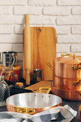 Fototapeta na wymiar Copper cookware with wooden kitchen utensils close up