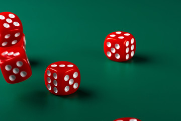 Red dice on green background close up