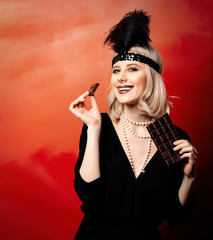 Beautiful blonde woman in twenties years clothes with chocolate slice