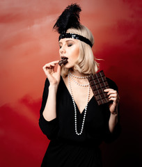 Beautiful blonde woman in twenties years clothes with chocolate slice