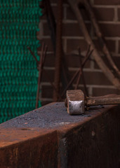 The hammer lies on the anvil in the forge