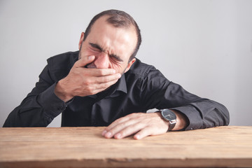Obraz premium Businessman suffering from tooth pain sitting in office.
