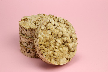 A stack of rice and buckwheat Crispbread on a pink background. Diet, proper nutrition, Vegan