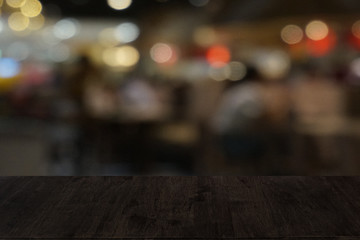 Empty dark wooden table in front of abstract blurred bokeh background of restaurant . can be used for display or montage your products.Mock up for space.