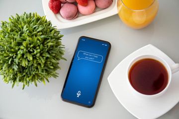 phone with app personal assistant on the screen in cafe