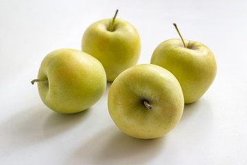 Yellow-green apples on a light background