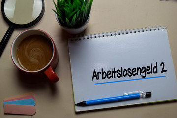 Arbeitslosengeld 2 write on a book isolated on office desk. German Language it means Unemployment Benefit