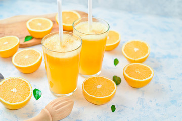 Glass of freshly squeezed orange juice and slices of orange fruit on white background