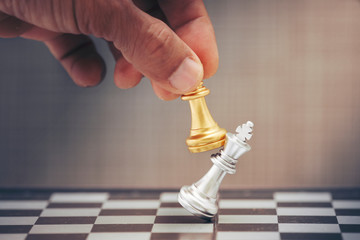 hand holding chess piece on chess board, business concept