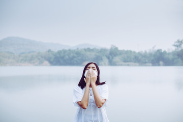 Asian woman using mask protect PM 2.5 because pollution at nature