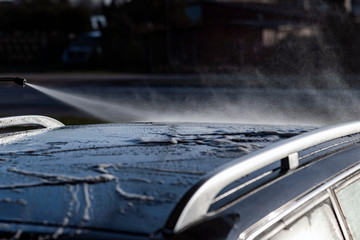 Washing of car by high pressure spray.