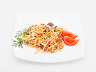 Stewed vegetables with meat: cabbage, onions, carrots and beef on a white plate on a white background