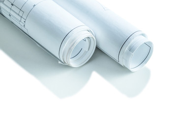 two white rolled up blueprints isolated very close  up
