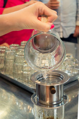 girl pours water from a glass jug into a cup