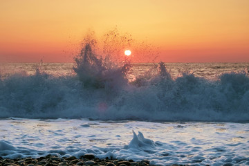 Fototapeta na wymiar Sunset sky behind splashing waves