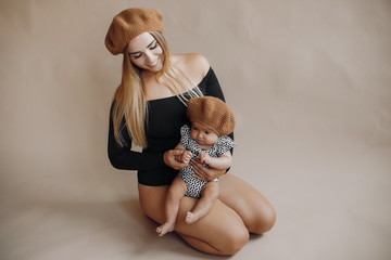 Mother with cute daughter. Blonde with long hair. Little child in a stylish clothes