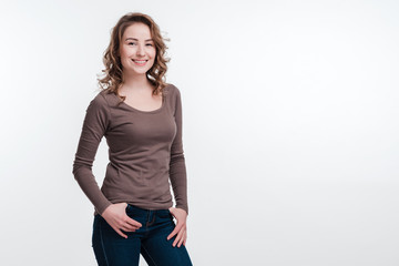 Fototapeta premium Beautiful model in brown shawl posing on white wall background. Place for advertising, copy space