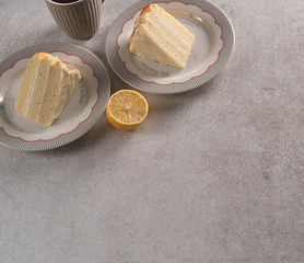 a dessert of a cake, lemon, cup of tea on a marble backdrop