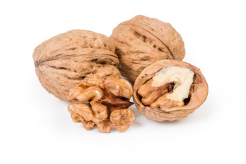 Whole and partly shelled walnuts on a white background