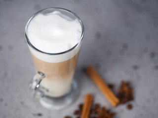 Glass of coffee latte with cinnamon on a concrete table