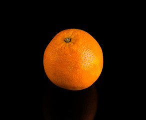 one bright juicy orange on a black background