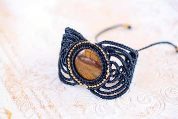 Stylish boho macrame string natural mineral stone bracelet on white decorative background