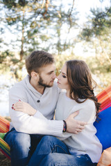 Couple in love, girl and guy in hammock enjoys in the woods, travel love story concept