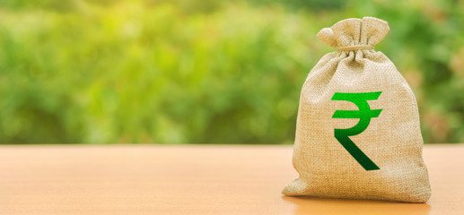 Indian rupee money bag on nature background. Profit, income, earnings. Finance and budgeting,...