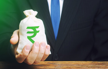 Man holds out a indian rupee money bag. Provision of money on credit, grant. Project financing....