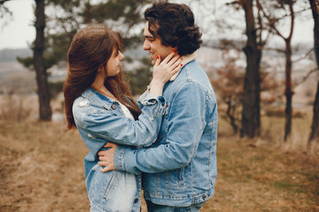 gentle and stylish couple are having a walk in the autumn park