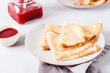 Crepes with strawberry jam on grey background. Pancake week, mardi gras, maslenitsa holidays. Selective focus