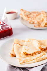 Crepes with strawberry jam on grey background. Pancake week, mardi gras, maslenitsa holidays. Selective focus