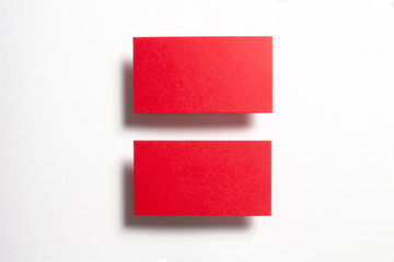 Two red blank matt linear textured business cards flying and isolated on white paper background, us standard size 3.5 x 2 inches, real professional studio photo.