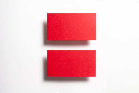 Two red blank matt linear textured business cards flying and isolated on white paper background, us standard size 3.5 x 2 inches, real professional studio photo.