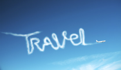 Fototapeta premium Airplane in sky drawing word travel.