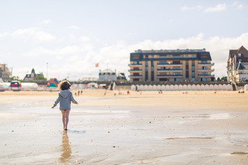 Enfant jouant sur la plage en Normandie