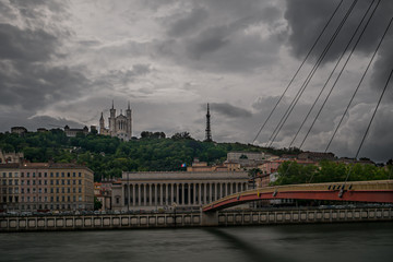Basilique de Fourviere on top of the hill in Lyon with a bridge crossing the river Saone in the foreground