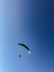 A man is engaged in paragliding. Parachute in the blue sky. Freedom.