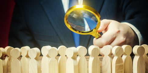 Businessman is studying a crowd of people with a magnifying glass. Hr search candidates for work,...