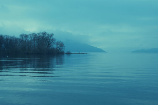 Moody landscape of a lake surrounded by hills and trees